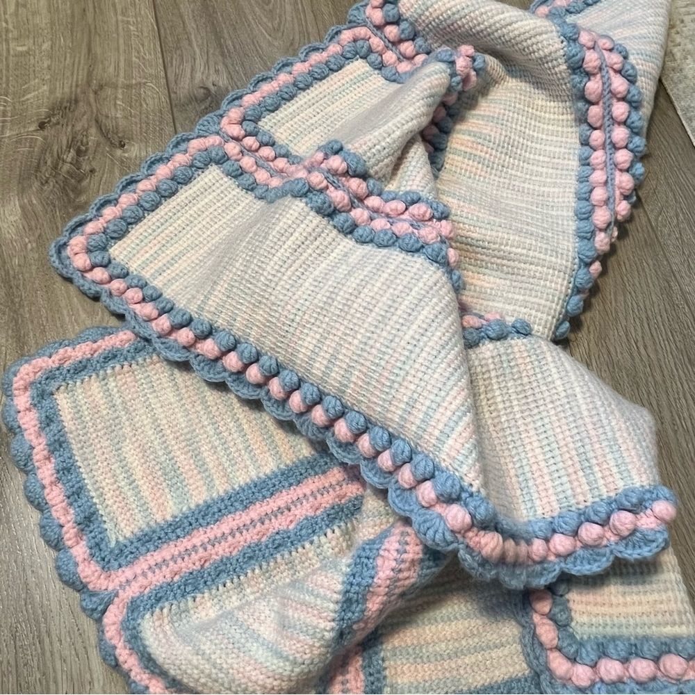 Hand Knitted Baby Blanket Blue and pink scalloped hem and pom pom edges.